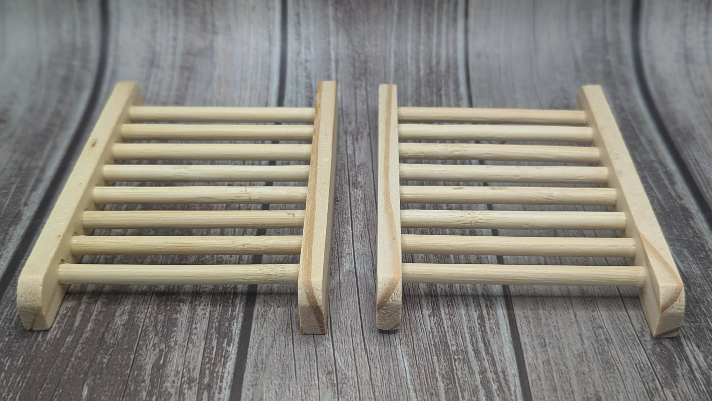Two wooden soap dishes on rustic wood background, slatted design for handcrafted soap drying
