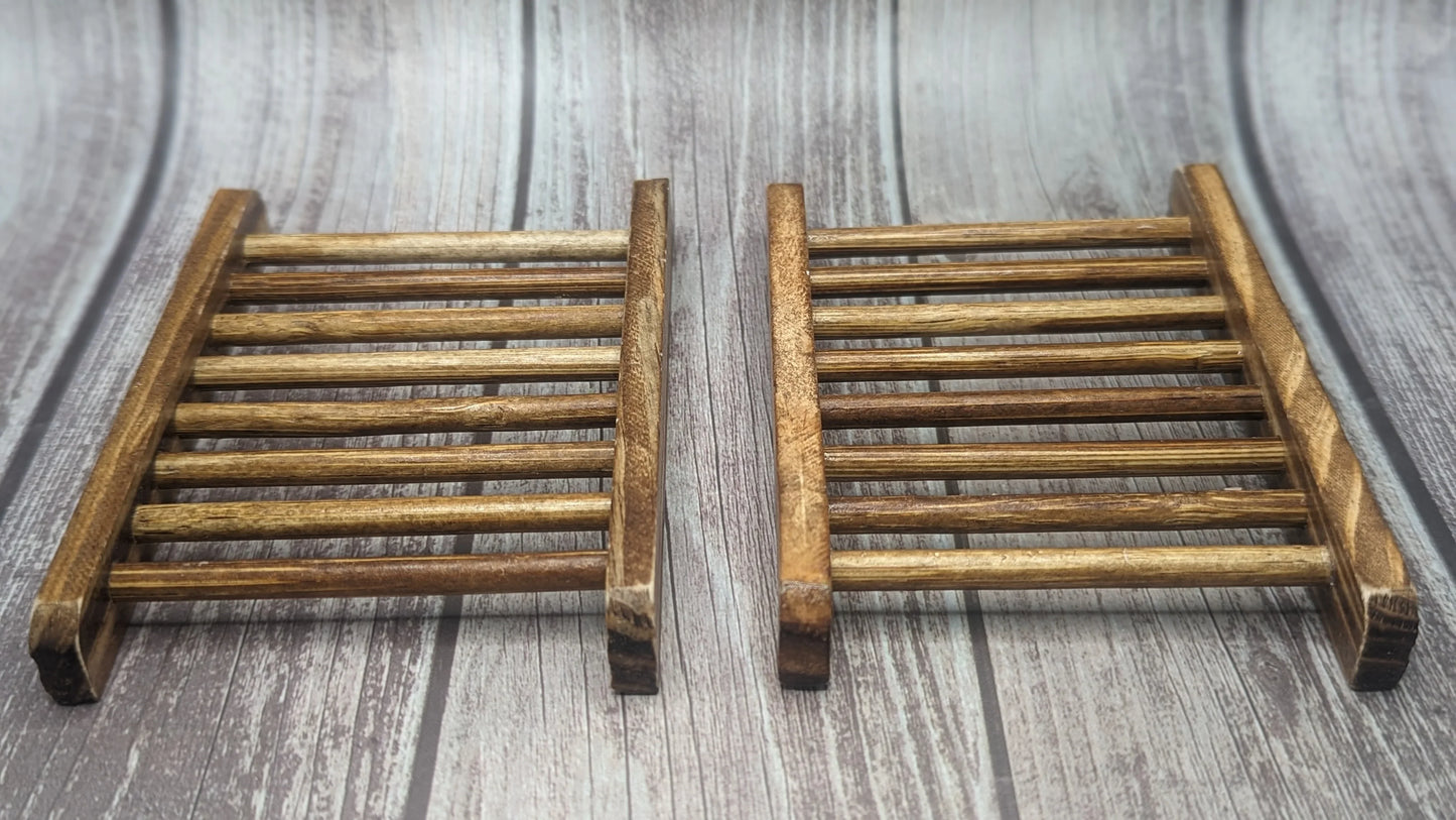 Two handcrafted wooden soap dishes on rustic wood background