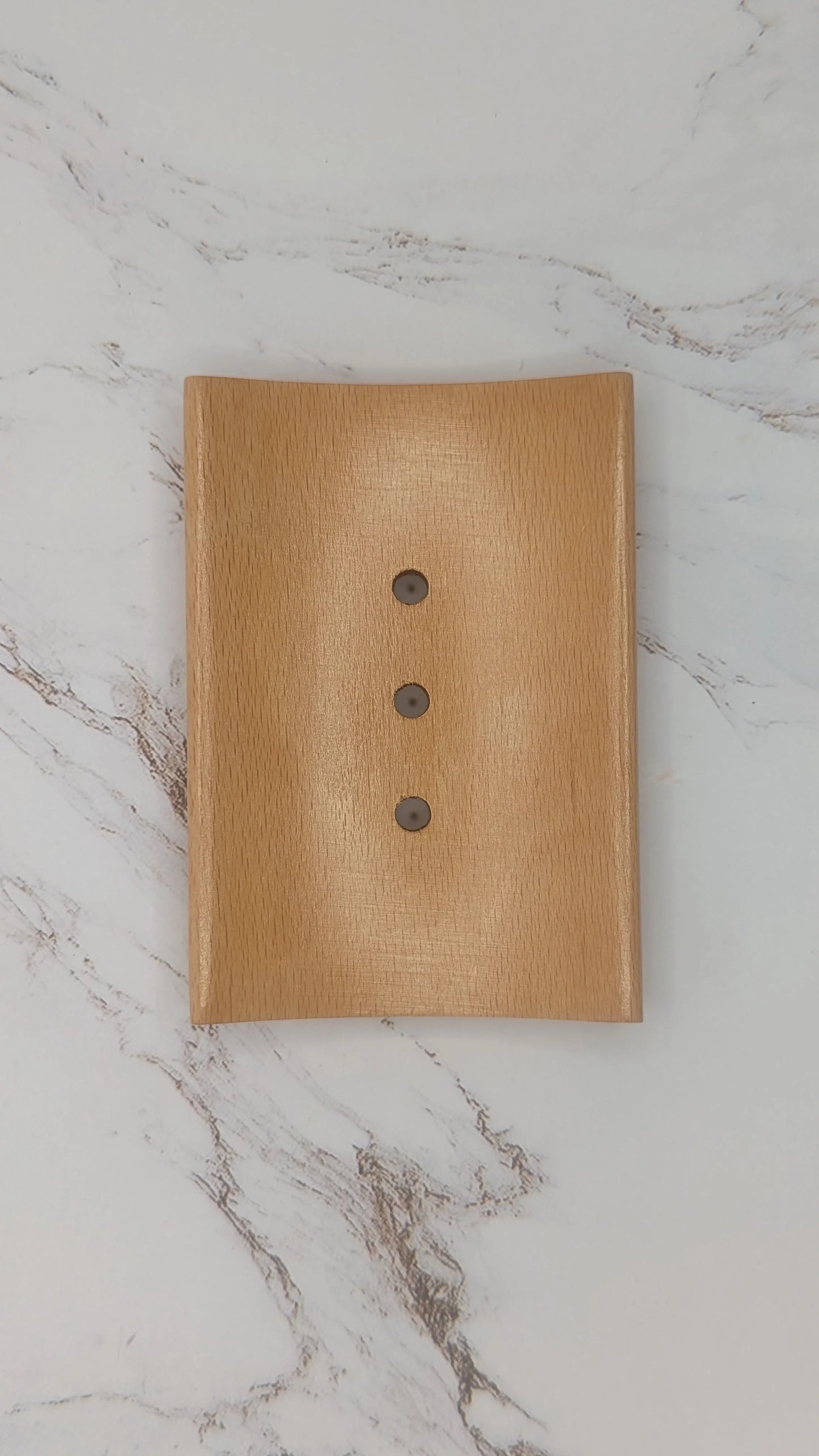 Rectangular wooden soap dish with drainage holes on white marble background