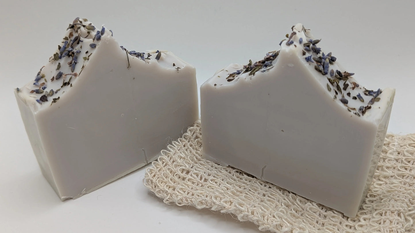Handcrafted lavender soap bars with dried lavender on top, displayed on a natural soap saver